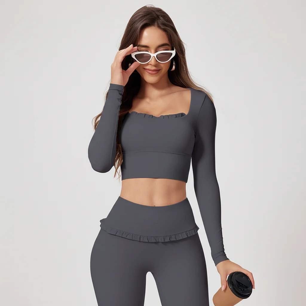 Woman wearing a gray athletic outfit with sunglasses on a light gray background
